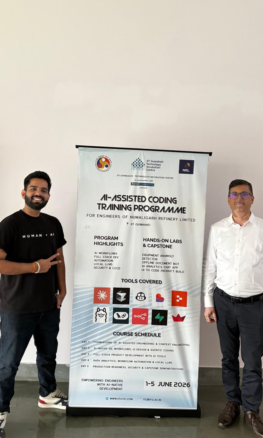 Aish beside the AI-Assisted Coding Training Programme banner at IIT Guwahati